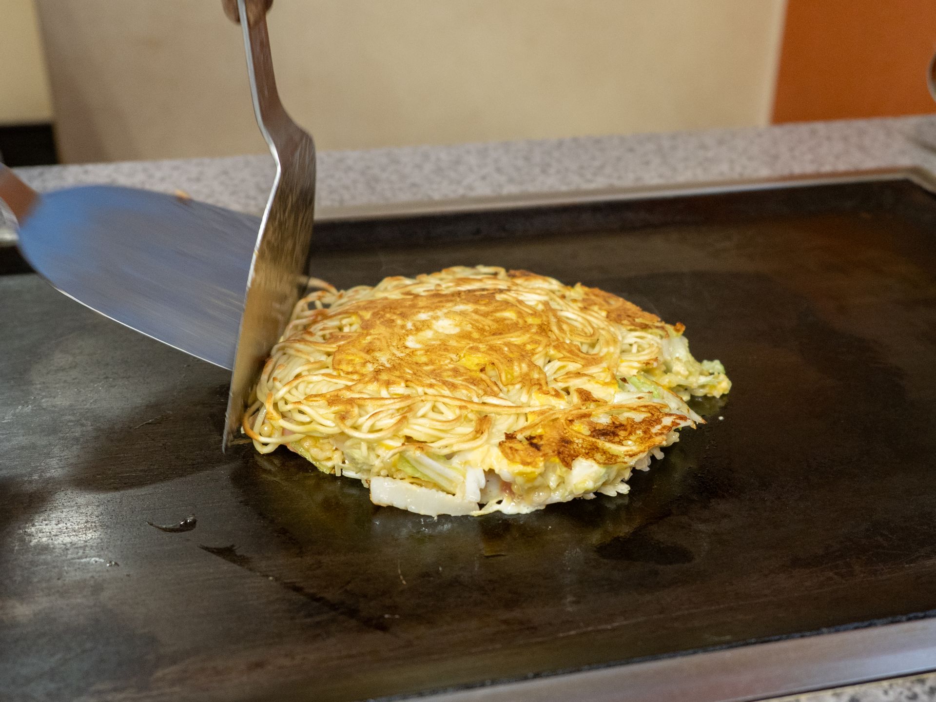 鉄板で焼かれるお好み焼き