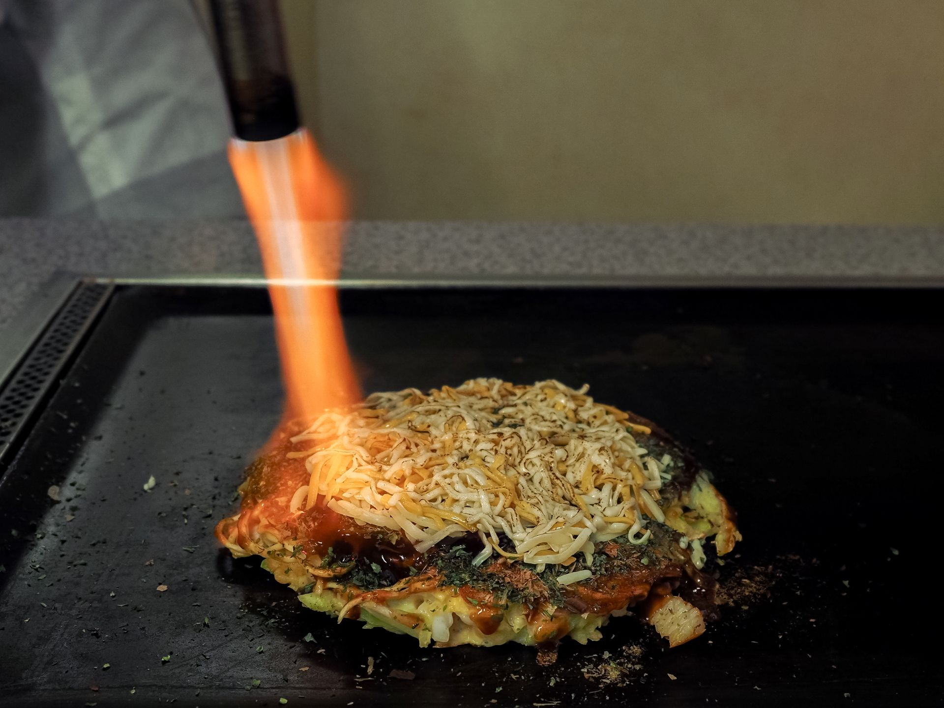 バーナーでお好み焼きを焼いている様子